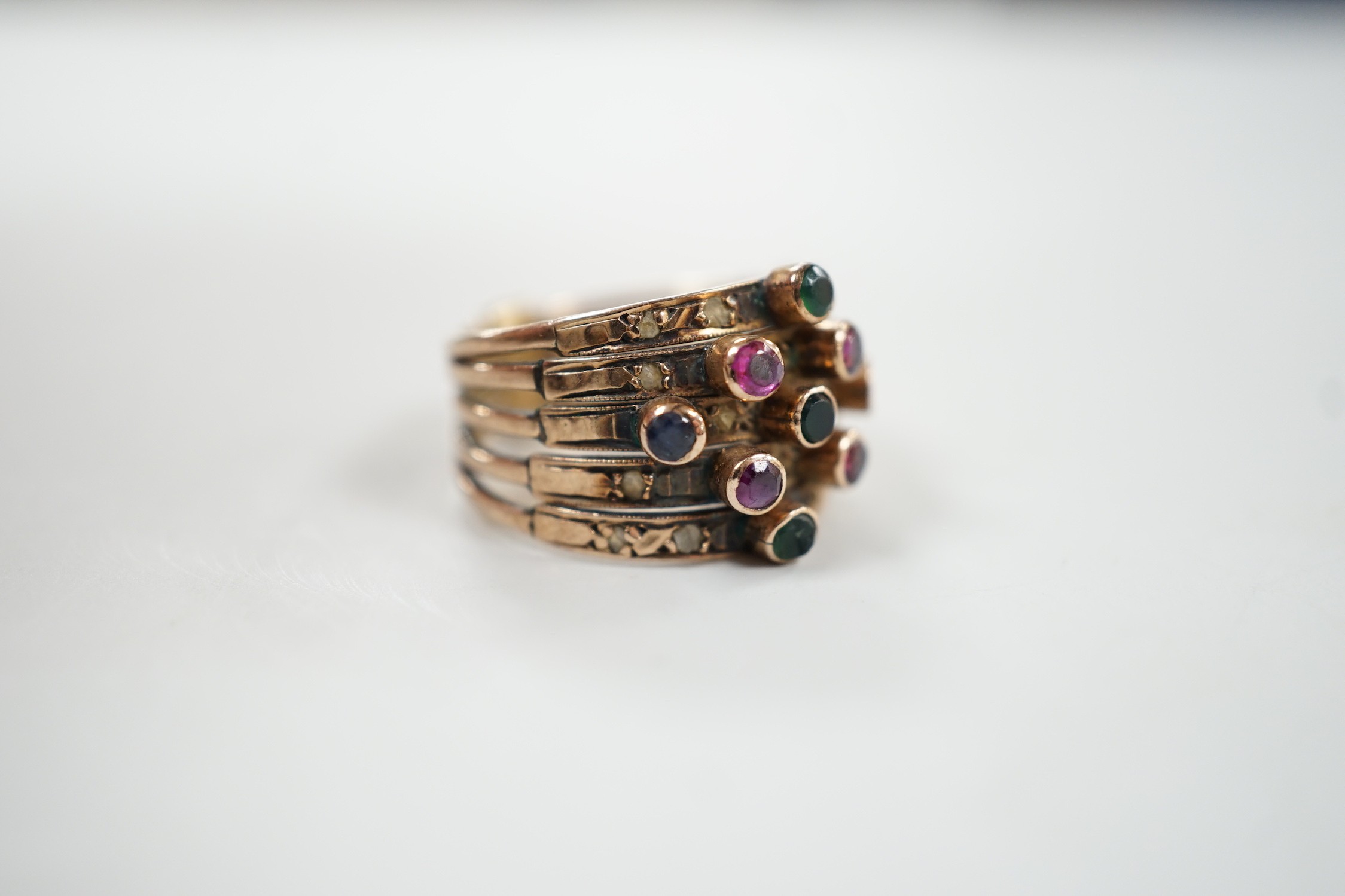 A yellow metal, quintuple band and multi gem set ring (stone missing), size H, gross weight 4.5 grams.